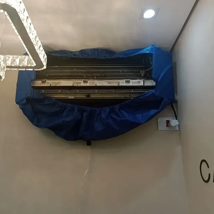 Ar-condicionado aberto com bolsa coletora azul durante a higienização